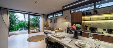 Una cocina moderna con comedor, ventanas amplias y vistas a zonas verdes.