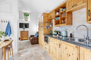 Eine moderne Küche mit Holzausstattung, Einbauherd und großem Fenster.