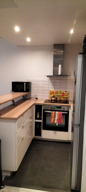 Eine kompakte Küche mit Mikrowelle, Backofen und Kühlschrank.