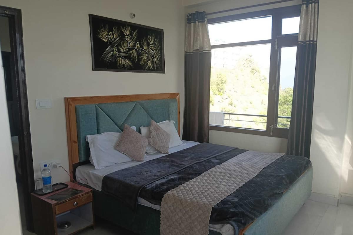 A bedroom with a bed, nightstand, and a painting above the bed.