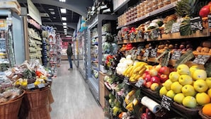A grocery store aisle with various fruits and vegetables on display. - Captivating Loft in Prime Location near Colosseum (Roma)