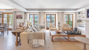 Ein geräumiges Wohnzimmer mit einer großen Couch, einem Couchtisch und einem Schachspiel.