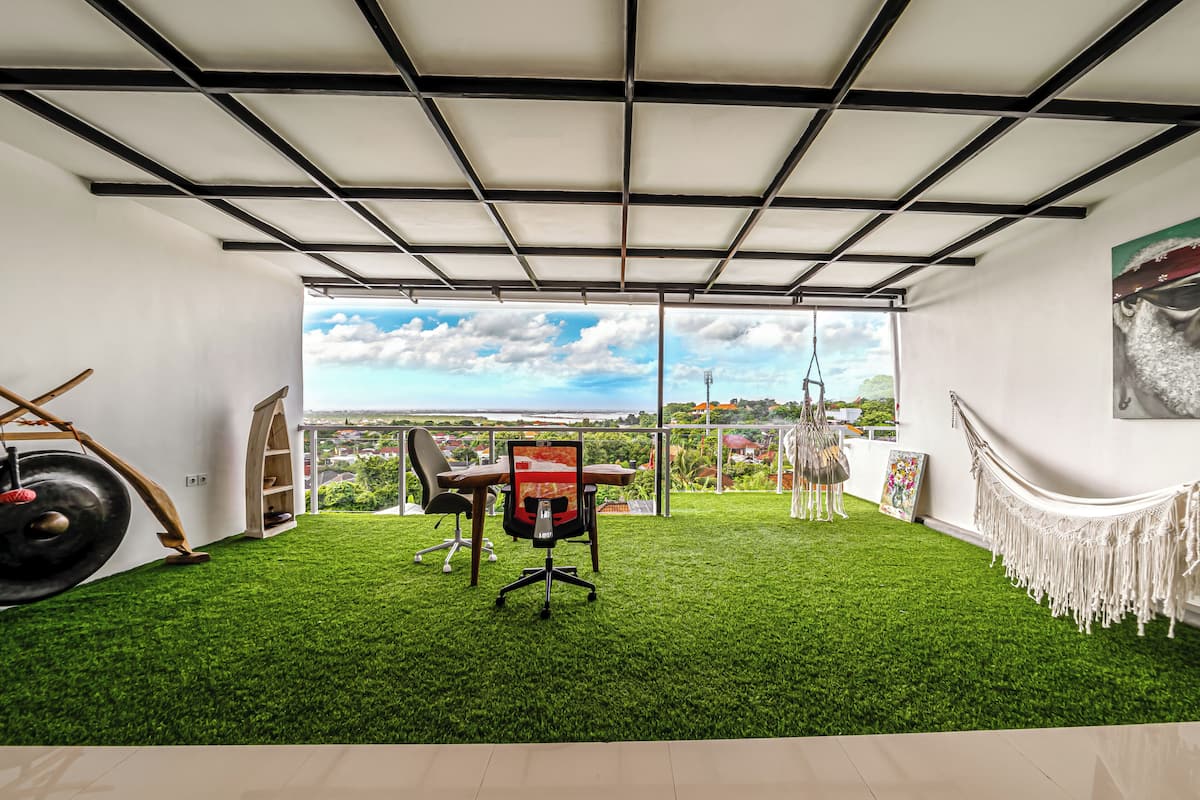 Una habitación con vistas, un escritorio, una silla y una hamaca.