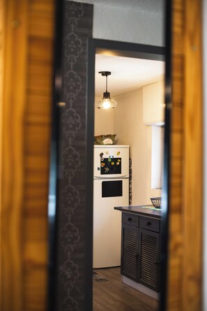 A kitchen with a refrigerator, a microwave, and a hanging light fixture. - Vielle-aure Le 2 Bers duplex (90 M2)cosy mountain living ☀️ (Vielle-Aure)