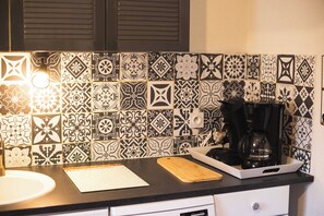 A kitchen with patterned tiles, a coffee maker, a cutting board, and a sink. - Vielle-aure Le 2 Bers duplex (90 M2)cosy mountain living ☀️ (Vielle-Aure)