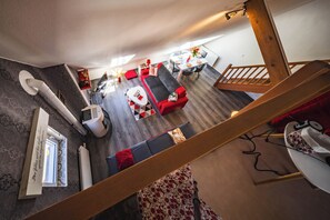Een modern interieur met een trap, een eethoek en een zithoek met een bank en een tafel.