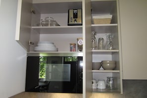 Eine Küche mit Einbaukühlschrank, einem Esstisch und einem Fenster mit Blick auf Grünflächen.