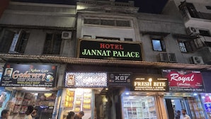 Hotel Jannat Palace with a signboard, adjacent shops, and a clear night sky. - Hotel Jannat Palace Near Jama Masjid (New Delhi)