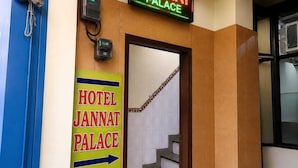 A hotel entrance with a sign for Hotel Jannat Palace, a telephone, and a staircase. - Hotel Jannat Palace Near Jama Masjid (New Delhi)