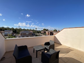 A rooftop terrace with outdoor furniture, a view of neighboring buildings, and a clear sky. - Th46 Casa Adosada en Salou Para 6 Personas (Salou)