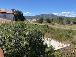 Zona residencial com casas, uma estrada e montanhas ao fundo.