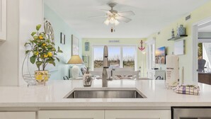 A kitchen with a white countertop, stainless steel sink, and a ceiling fan. - Oceanfront 3BD/2BA-First Floor-Beautifully Decorated-Family Friendly (North Myrtle Beach)