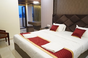Quarto de hotel com uma cama grande, uma mesa e uma cadeira.