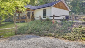 A white building with a wooden deck and a gravel driveway. - Sleek Hillside Getaway in Brevard, Dogs Welcome! (Brevard)