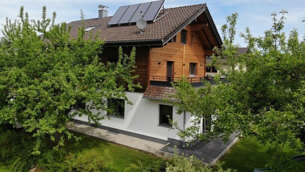 A modern two-story house with solar panels, a sloped roof, and a white exterior wall. - Apartment Sonnseite for max. 5 persons with sun terrace (Teisendorf)