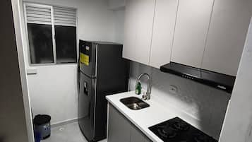 Frigorífico, placa de cocina, cafetera o tetera y utensilios de cocina