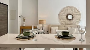 Et moderne spiseområde med et marmorbord, to grønne skåle og vinglas.
