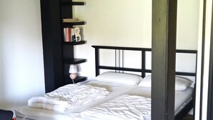 A room with a bed, a desk, and a bookshelf. - Vacation apartment Glock 6 (Siegsdorf)