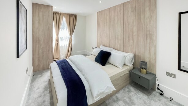 Una camera da letto moderna con un letto, un comodino e una abat-jour.
