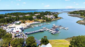 Un port de plaisance avec des bateaux amarrés, un bâtiment en construction et des quartiers résidentiels environnants.