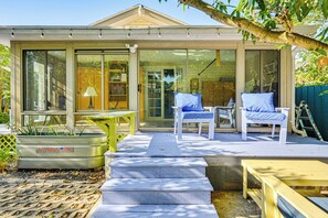 Ein Haus mit einer überdachten Terrasse, Sitzgelegenheiten im Freien und einem mit TARTER gebrandeten Pflanzgefäß.