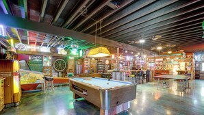 A pool table in a room with arcade games and neon signs. - Hike, Soak + Play: Rustic Maysville Escape! (Maysville)