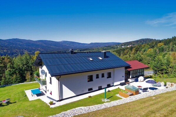 A modern house with a solar panel roof, a swimming pool, and a view of mountains. - Holiday apartment in Mauth with swimming pool (Mauth)