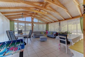A spacious room with a wooden ceiling, a sofa set, a table, and a foosball table. - Holiday apartment in Mauth with swimming pool (Mauth)