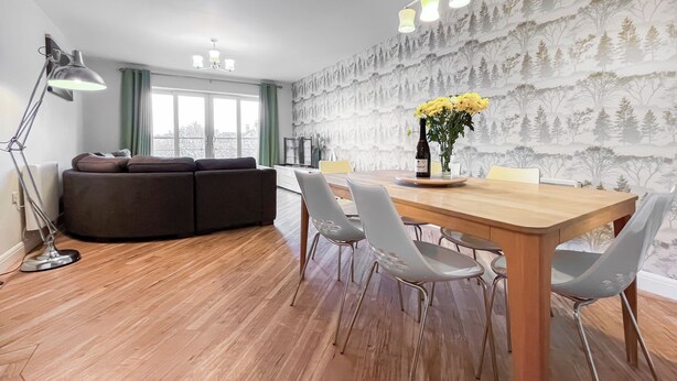 Um espaço de estar moderno com área de jantar, sofá e mesa de jantar com cadeiras.