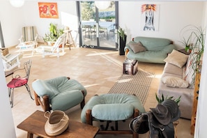 Ein geräumiger Wohnbereich mit Sofa, Sesseln und Esstisch.