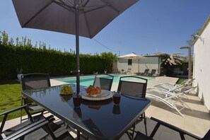 An outdoor dining area with a pool, chairs, and a table with food and drinks. - Villa Benvenuti al Sud (Roccazzo)