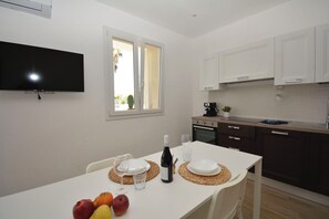 A modern kitchen with white cabinets, a built-in oven, and a coffee machine. - Villa Benvenuti al Sud (Roccazzo)
