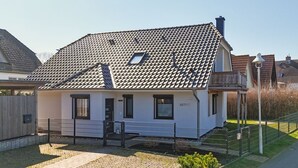Et etplanshus med tegltag, en veranda og et lille haveareal.
