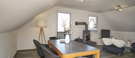 Un loft moderno con comedor, chimenea y una zona de estar acogedora.