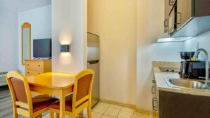 A compact kitchen with a dining table and chairs, a built-in oven, and a sink. - Studio 6 Bakersfield_2 Full Beds | Smoki (Bakersfield)