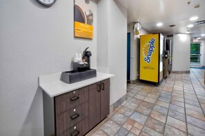 A hallway with a reception desk, a clock, and a Snapple vending machine. - 2 Full Beds | Accessible, Non-Smoking (Benbrook)