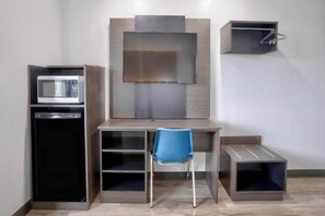 A compact room with a kitchenette, a desk, a chair, and a TV mounted on the wall. - 2 Full Beds | Accessible, Non-Smoking (Benbrook)