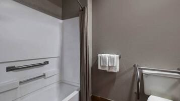 A bathroom with a shower, toilet, and towel rack.