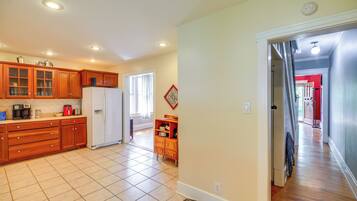 A spacious kitchen with wooden cabinets, a refrigerator, and a dining area with a window.