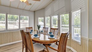 A dining area with a round table, wooden chairs, and a ceiling fan. - Amazing Views! Family-Friendly Badin Lake House! (New London)