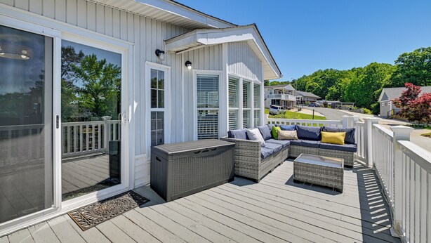 A covered deck with outdoor furniture, a sliding glass door, and a view of the neighborhood. - Amazing Views! Family-Friendly Badin Lake House! (New London)