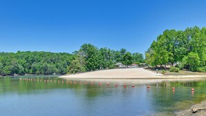 A lake with a sandy beach, surrounded by dense green trees. - Amazing Views! Family-Friendly Badin Lake House! (New London)