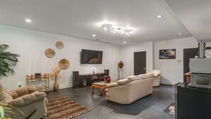 A modern living room with a sofa, coffee table, and a flat-screen TV. - Hike, Boat & Explore! Serene Stafford Apt w/ Patio (Stafford)