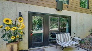 A patio with a chair, a welcome mat, and a potted plant with sunflowers. - Hike, Boat & Explore! Serene Stafford Apt w/ Patio (Stafford)