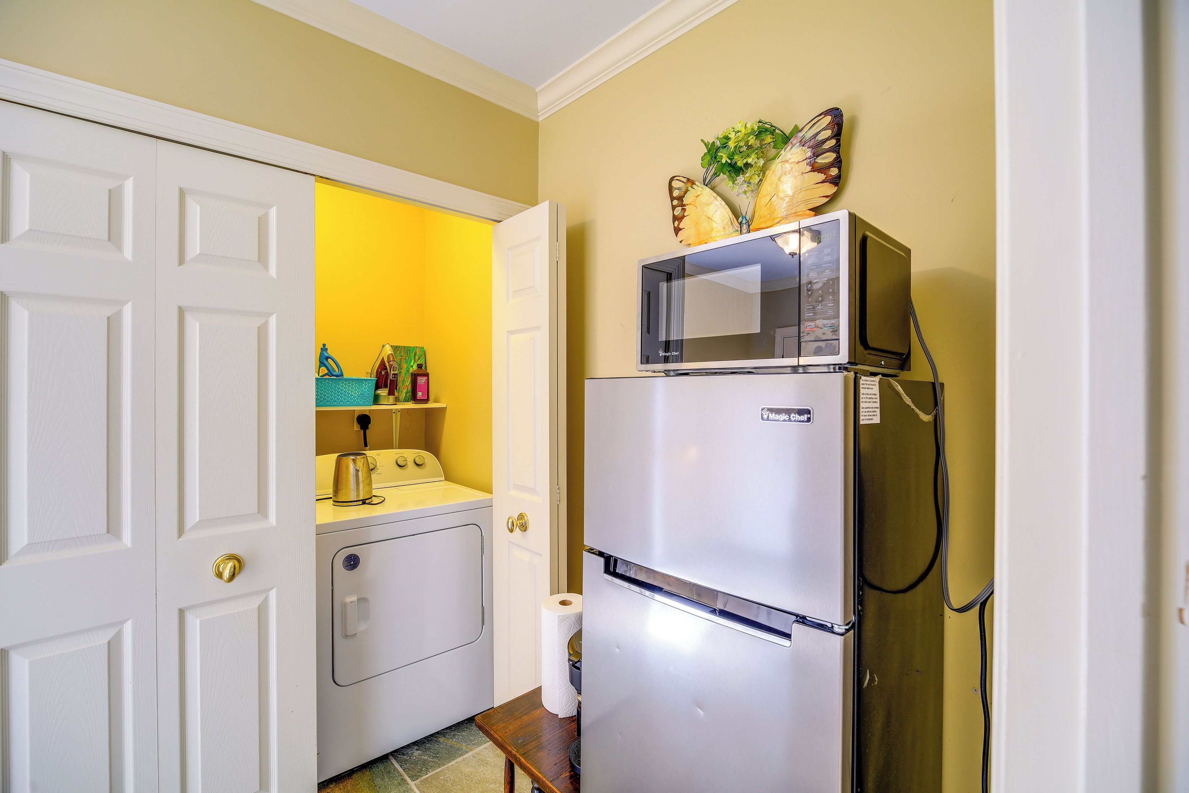 A compact kitchen with a refrigerator, microwave, and a washing machine.