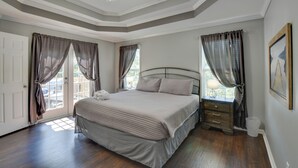 Un dormitorio con cama, cortinas, ventilador de techo y ventana.