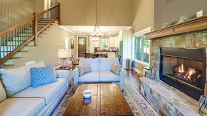 Un salon spacieux comprenant un canapé, une table basse, une cheminée et un escalier.