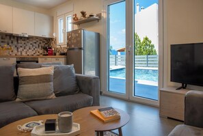 Ein modernes Wohnzimmer mit Sofa, Couchtisch und Fernseher.