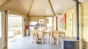 Un interior de madera con una mesa de comedor, sillas, una estufa y un calentador.