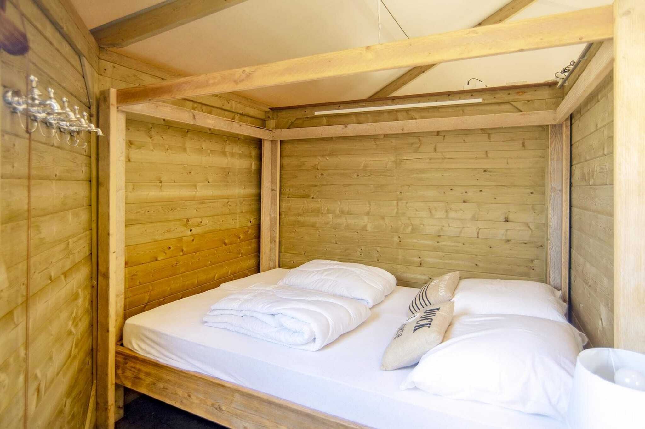 Une pièce de style cabane en bois, avec un lit simple, des murs en bois et un aménagement simple.